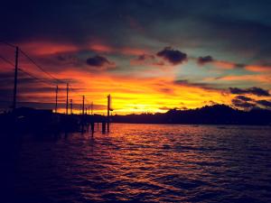a sunset over a body of water with the sun setting at Kunyit 7 Lodge in Bandar Seri Begawan