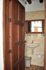 a bathroom with a sink and a wooden door at Hospedaje Donde Lorenzo in Barichara