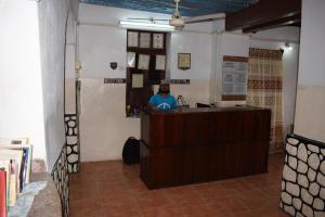 a woman sitting at a counter in a room at Karibu Inn in Zanzibar City