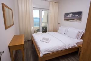 a bedroom with a large bed and a window at Apartments Vela Sollis in Marusici  +77 photos