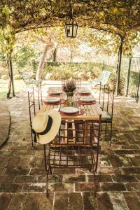 La Veronica Exclusive Chianti Resort في غريفي ان شنتي: طاولة خشبية عليها كراسي وقبعة