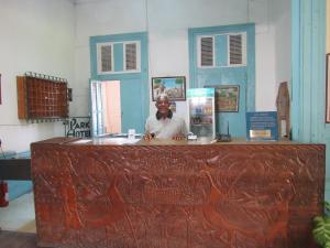 un hombre parado detrás de un mostrador en una habitación en Park Hotel, en Puerto Príncipe