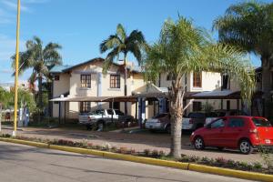 una casa con palmeras y coches estacionados frente a ella en Rio Apart Hotel en Federación