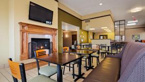 a dining room with tables and a fireplace at Best Western Ambassador Inn & Suites in Wisconsin Dells