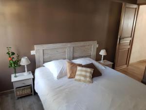 a large white bed with two pillows on it at Le Leon d'or in Mirepoix