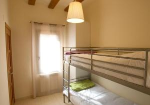 a bedroom with two bunk beds and a window at Cal Metge de Gualba in gualba de Dalt