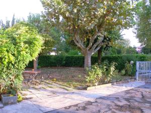 einen Garten mit einem Baum, einem Tisch und Stühlen in der Unterkunft Bed & Breakfast Anzola in Anzola dell'Emilia