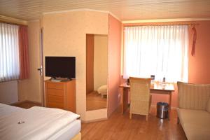 - une chambre avec un lit et un bureau avec une télévision dans l'établissement Landgasthof Buch, à Eichenzell