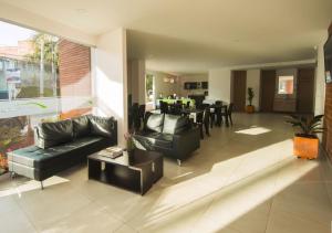 a living room with couches and a dining room at Hotel Valle de San Nicolas in Rionegro