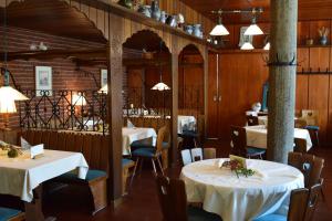 une salle à manger avec des tables et des chaises blanches dans l'établissement Landgasthof Buch, à Eichenzell