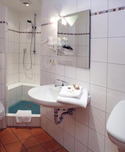 a white bathroom with a sink and a shower at Landgasthof Buch in Eichenzell