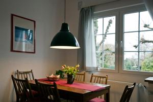 un comedor con una mesa con sillas y una lámpara en Sieben Linden, en Remscheid