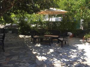 un patio con mesa, sillas y sombrilla en Residencia Beira Baixa, en Monfortinho