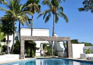 a villa with a swimming pool and palm trees at Gran Hotel Las Fuentes in Ciudad Victoria