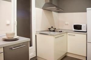 una piccola cucina con armadietti bianchi e forno a microonde di Barcelonaguest a Barcellona