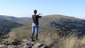 Un uomo in piedi sulla cima di una montagna che scatta una foto di Hotel Fazenda Itáytyba a Tibagi