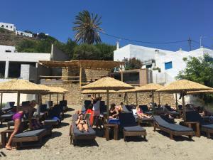 a group of people sitting on the beach under umbrellas at Antigoni in Skiros
