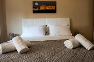 1 dormitorio con cama blanca y almohadas blancas en Gazi Divine Apartment, en Atenas