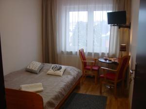Schlafzimmer mit einem Bett, einem Tisch und einem Fenster in der Unterkunft Villa Tabu in Posen