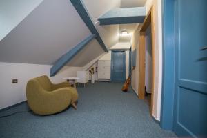 a room with a green chair and a blue ceiling at Penzión Banská Klopačka in Hnilčík