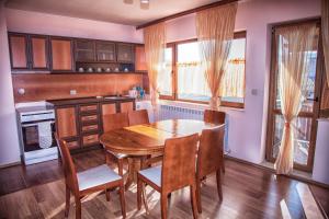 a kitchen with a wooden table and chairs at Valevitsata Guesthouse in Razlog
