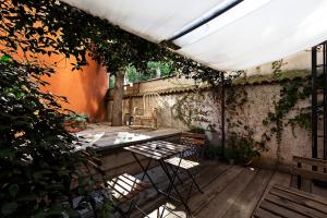 a patio with a table and chairs and ivy at Tiaré Home Milano in Milan