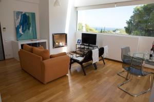 a living room with a couch and a table and a television at Infinity White Complex by GK Hospitality Group in Porto Rafti