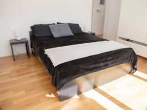a bedroom with a large bed with black and white sheets at Infinity White Complex by GK Hospitality Group in Porto Rafti +78 photos