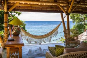 - un hamac sur une terrasse couverte donnant sur l'océan dans l'établissement Aquamarine Beach Villas, à Amed