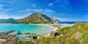 a beach with a bunch of boats in the water at La Costa Rooms in Flumini di Quartu