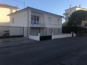 ein weißes Haus mit einem Zaun an der Straßenseite in der Unterkunft Gite Le Logis Dauphinois in Roussillon en Isere