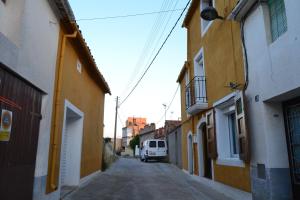 una furgoneta está estacionada en un callejón estrecho con edificios en Cal Llorenç, en Sant Pere Sacarrera