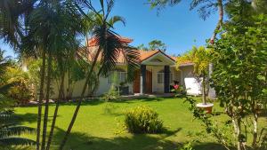 una casa con un patio verde con palmeras en Villa Talanquera, en Las Galeras