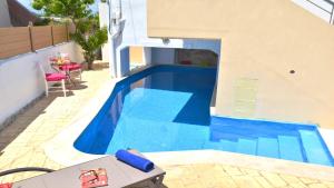 a blue swimming pool with a table and chairs in a house at Casa Nerium in Sfakaki