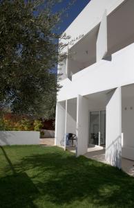 a white house with a lawn in front of it at Infinity White Complex in Porto Rafti