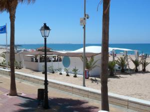 a street light next to a beach with palm trees at Macavi in Rota