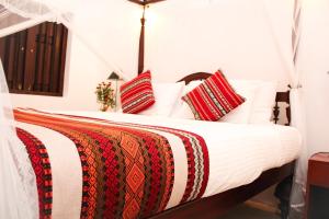 a bed with red and white pillows on it at Fort Bliss in Galle
