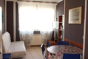 ein Wohnzimmer mit einem Tisch, einem Stuhl und einem Fenster in der Unterkunft La casa del Darda 3 in Ancona