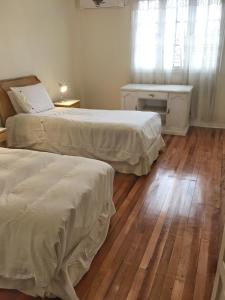 1 dormitorio con 2 camas, mesa y ventana en Casa Ryan en Santiago