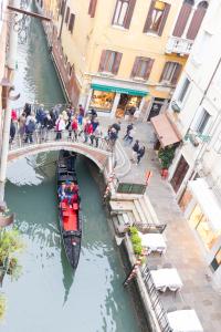a boat traveling under a bridge in a canal at Residence SanMarco in Venice