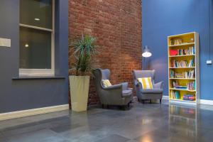 two chairs and a book shelf in a library at Best Western Melbourne City in Melbourne