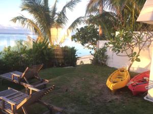a yellow kayak sitting next to two chairs and a house at Raina Holiday Accommodation in Rarotonga