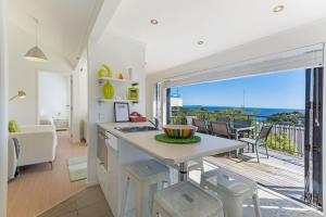 a kitchen and living room with a view of the ocean at Villa Casita at Palm Beach by Waiheke Unlimited in Palm Beach