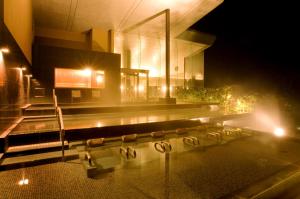 un edificio con piscina por la noche en Onyado Toho, en Aizuwakamatsu