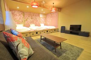 a living room with two beds and a coffee table at Stay SAKURA Tokyo Asakusa Townhouse in Tokyo