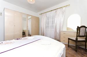 1 dormitorio con 1 cama, 1 silla y 1 ventana en Apartments Smilja, en Tribunj