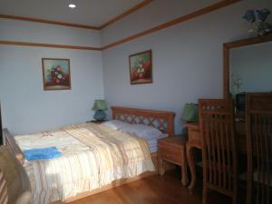 1 dormitorio con cama, tocador y espejo en VIP condo rayong Thai style, en Ban Phe