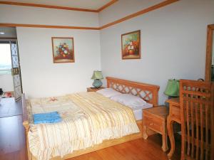 a bedroom with a bed and a night stand and a table at VIP condo rayong Thai style in Ban Phe