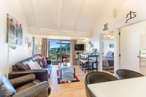 a living room with a couch and a table at Villa Topaz at Palm Beach by Waiheke Unlimited in Palm Beach