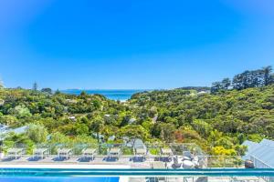 an aerial view of a house with a swimming pool and the ocean at Villa Topaz at Palm Beach by Waiheke Unlimited in Palm Beach